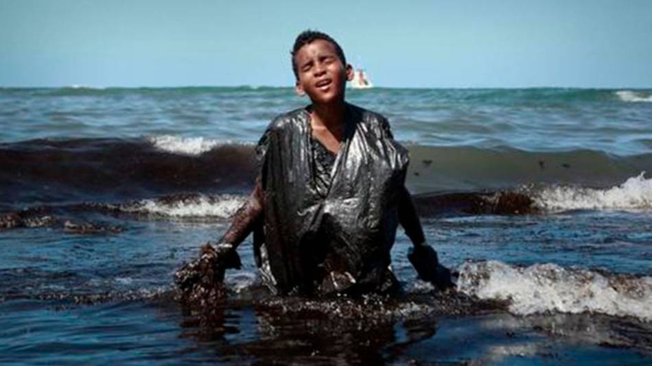 La historia detrás de la foto del chico cubierto de petróleo en las playas de Brasil