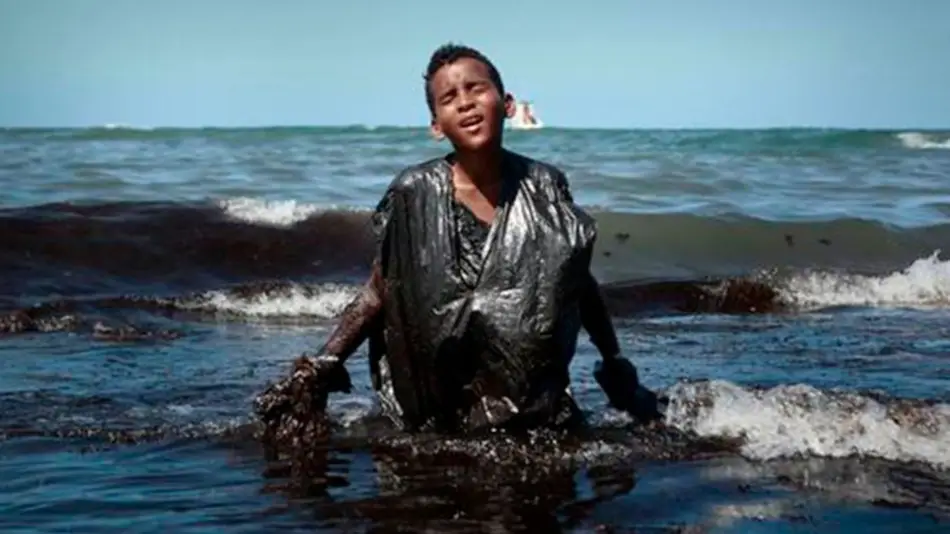 La historia detrás de la foto del chico cubierto de petróleo en las playas de Brasil